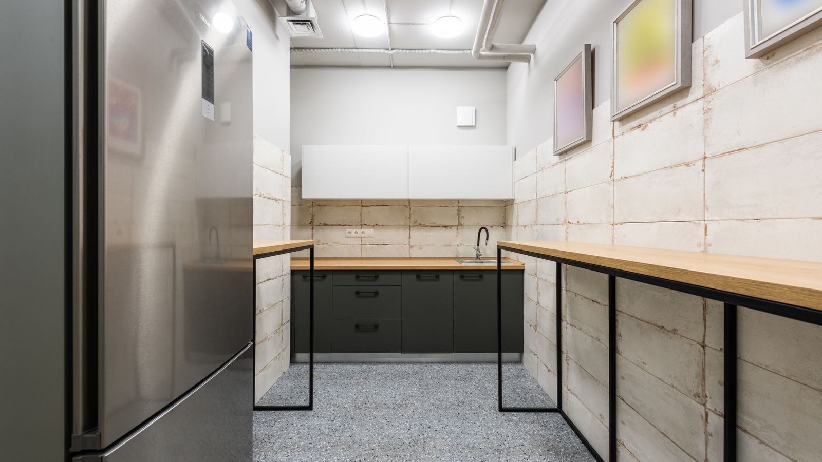 Modern office kitchen and break area with counters and seating